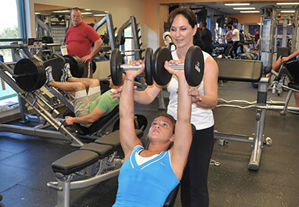 Photo of Oksana working out with free weights.